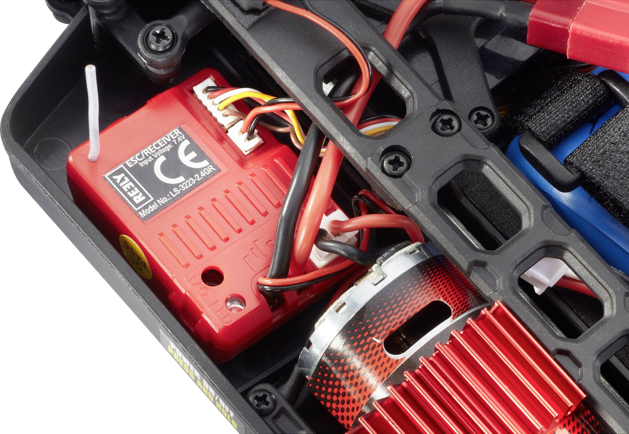 Zbliżenie zdalnie sterowanego pojazdu z fokusem na czerwone komponenty elektryczne i przewody wewnątrz.