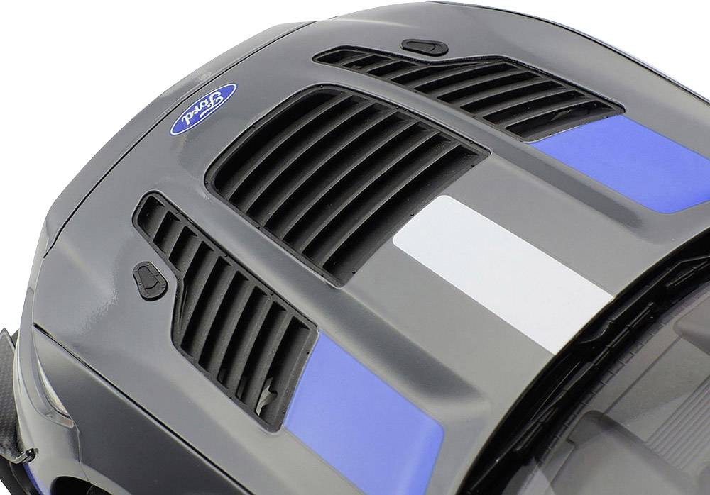 Zbliżenie szarego samochodu z niebiesko-białymi paskami na masce i otworami wentylacyjnymi, widoczne logo 'Ford'.