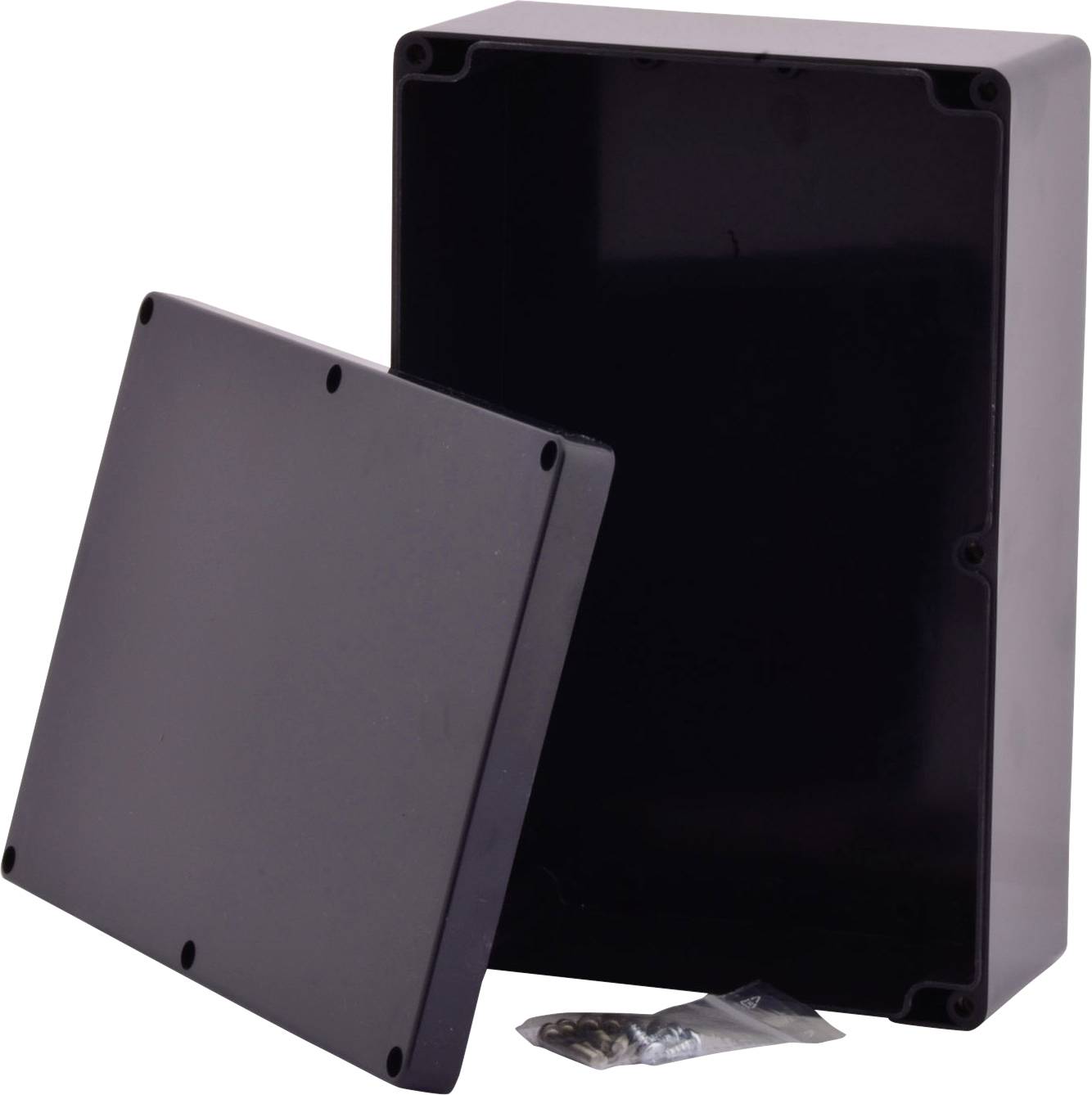 Czarna plastikowa skrzynka z zdejmowaną pokrywą oraz małymi śrubkami w woreczku.