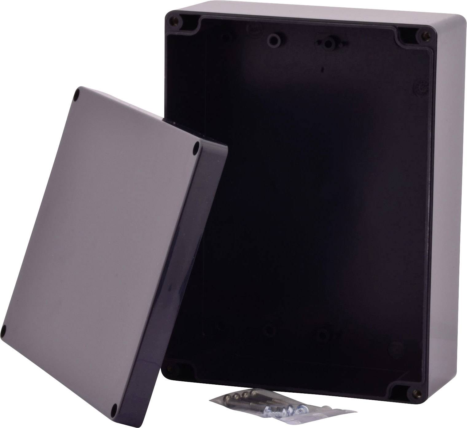 Prostokątna, ciemnoszara obudowa z otwartą pokrywą, pod którą znajdują się śruby i kołki, odpowiednia do montażu elektroniki.