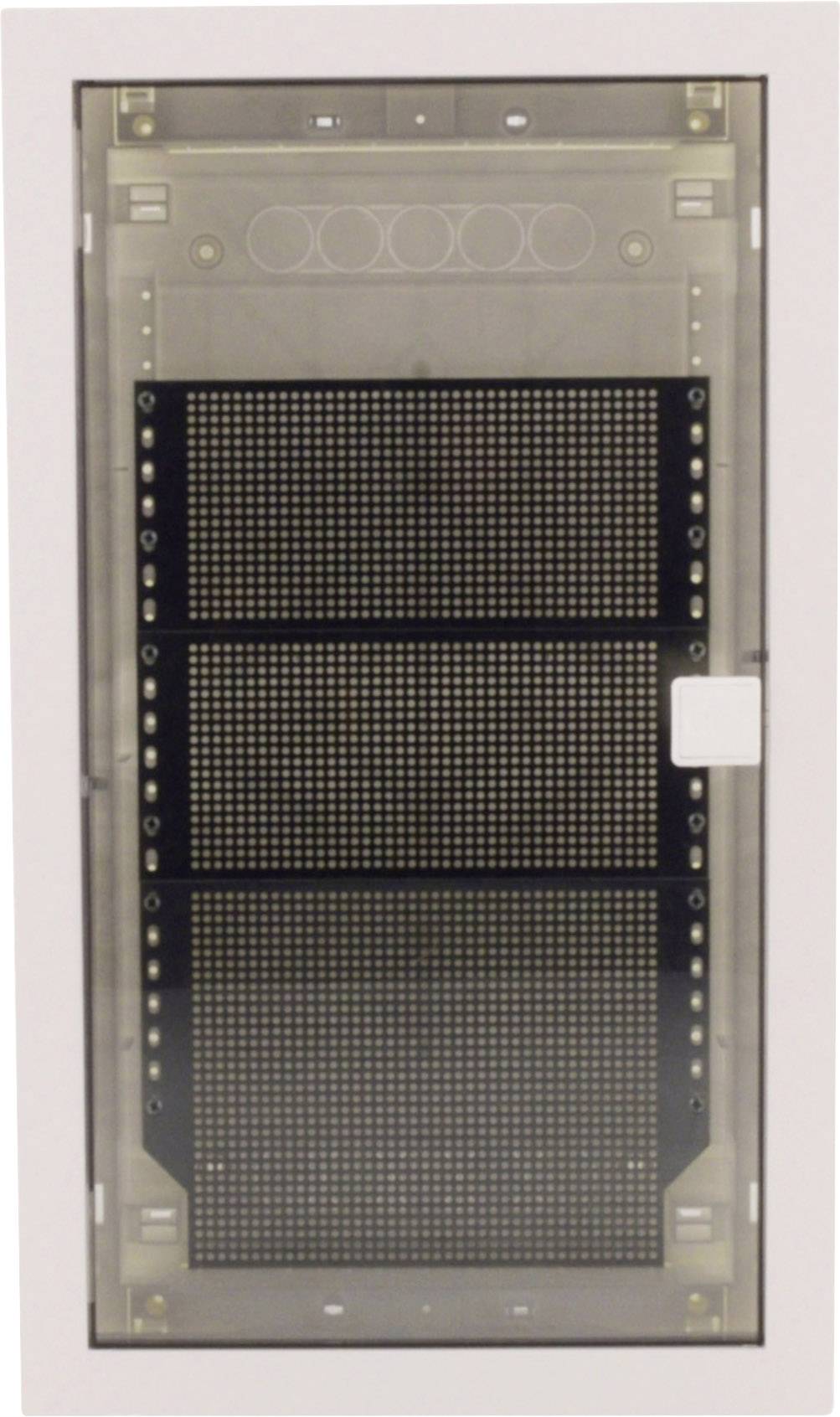 Pokrywa skrzynki bezpiecznikowej z przezroczystego tworzywa sztucznego, pod którą znajduje się czarna płyta z kilkoma rzędami małych otworów.