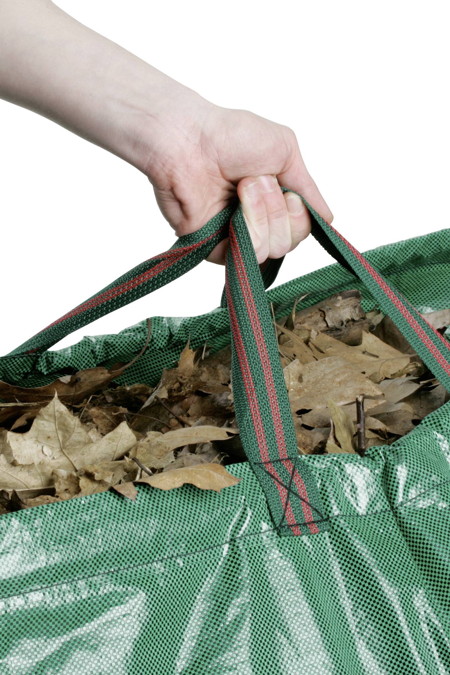 Dłoń trzyma zieloną plastikową torbę pełną brązowych jesiennych liści.