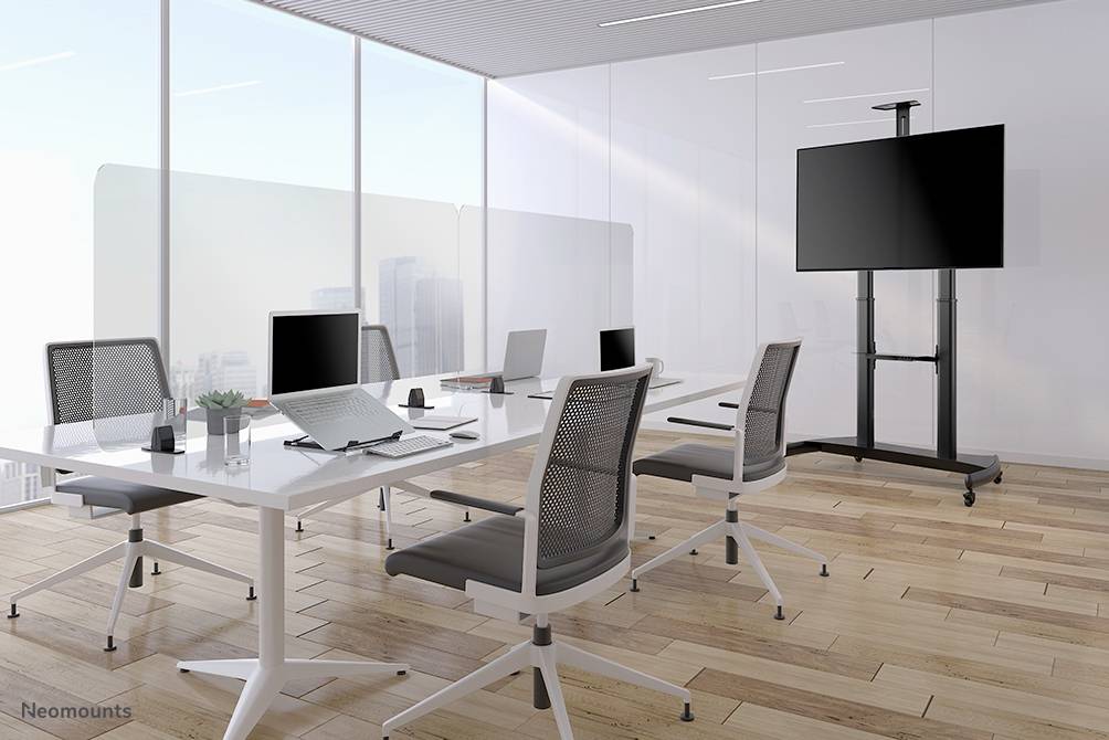 Nowoczesna sala konferencyjna z dużymi oknami, sześcioma obrotowymi krzesłami, dużym stołem z laptopami oraz ekranem prezentacyjnym.