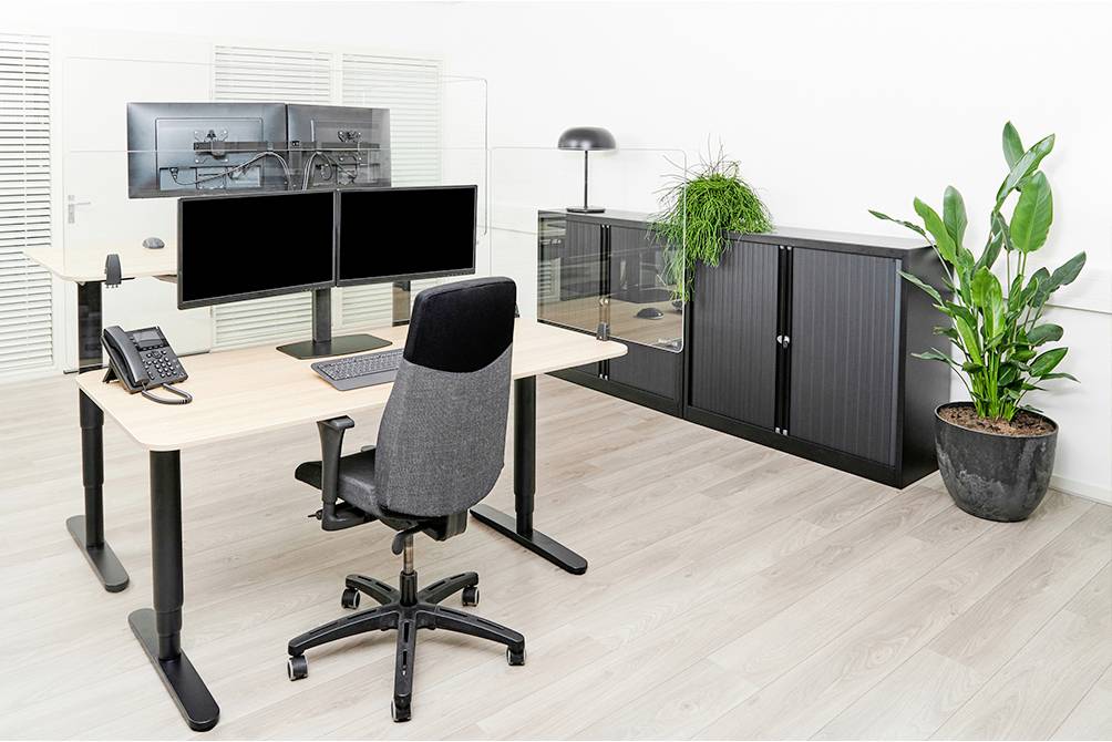 Nowoczesne biuro z ergonomicznym biurkiem, krzesłem, dwoma monitorami i roślinami, tworzące produktywne środowisko pracy.