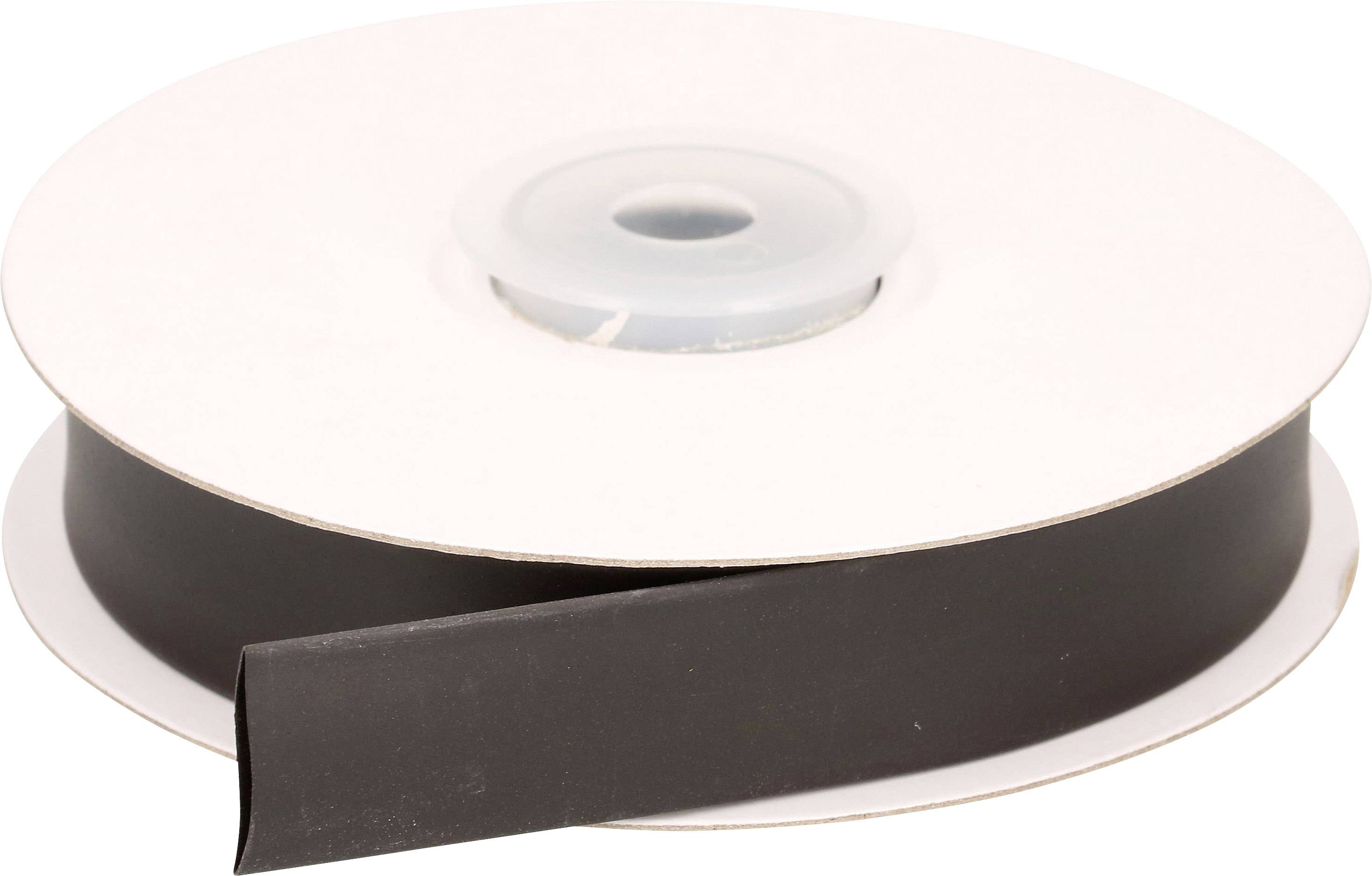 Czarna rolka taśmy magnetycznej, częściowo rozwinięta, leży na stole.