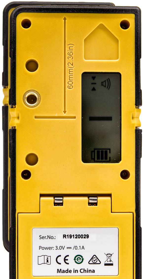 Żółte urządzenie elektroniczne z wyświetlaczem, wskaźnikiem baterii, numerem seryjnym 'R19120029'. Oznaczenia wysokości: 60 mm (2,36 cala). Kraj pochodzenia: Chiny.