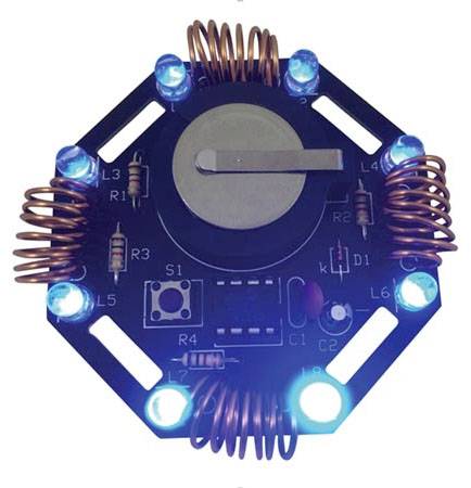 Sześciokątne urządzenie elektroniczne z widocznymi niebieskimi diodami LED, cewkami i centralną baterią, przedstawiające elementy obwodu elektronicznego.