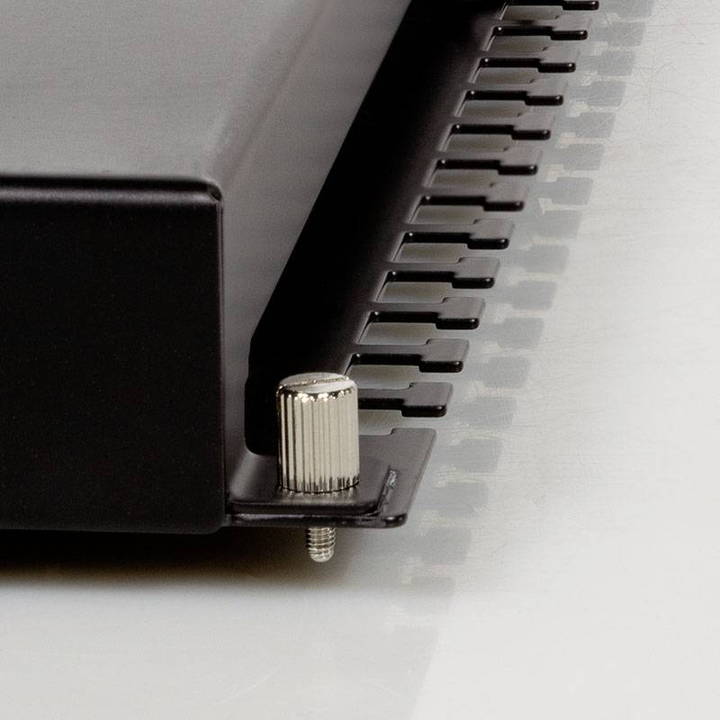 Zbliżenie obudowy metalowej z śrubą mocującą i żeberkami chłodzącymi. Szczegół techniczny urządzenia elektronicznego.