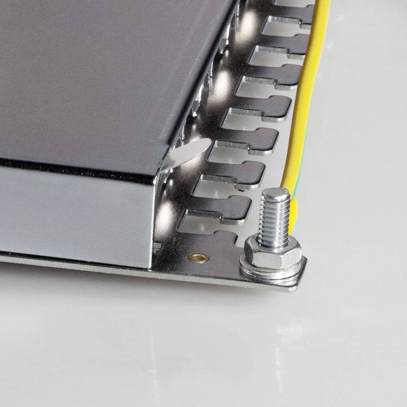 Zbliżenie metalowego podzespołu elektronicznego z widocznymi śrubami i przewodami, prawdopodobnie stanowiącego część większego urządzenia.