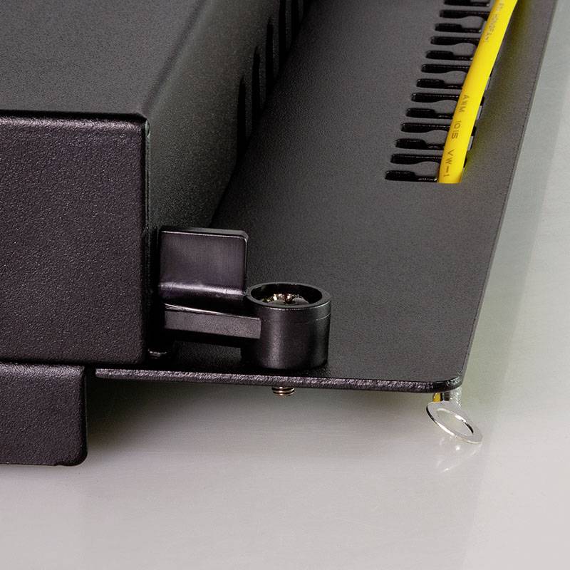 Zbliżenie maszyny introligatorskiej z żółtymi plastikowymi elementami spinającymi.