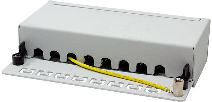 Metalowa skrzynka do prowadzenia kabli z wieloma otworami, do której włożono żółty kabel.