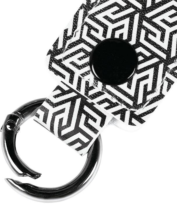 Brelok z czarno-białym wzorem geometrycznym i okrągłym czarnym guzkiem.