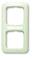 Prostokątna, pionowa, miętowozielona rama z dwoma pustymi wycięciami, odpowiednia do zakrycia gniazdek elektrycznych lub włączników.