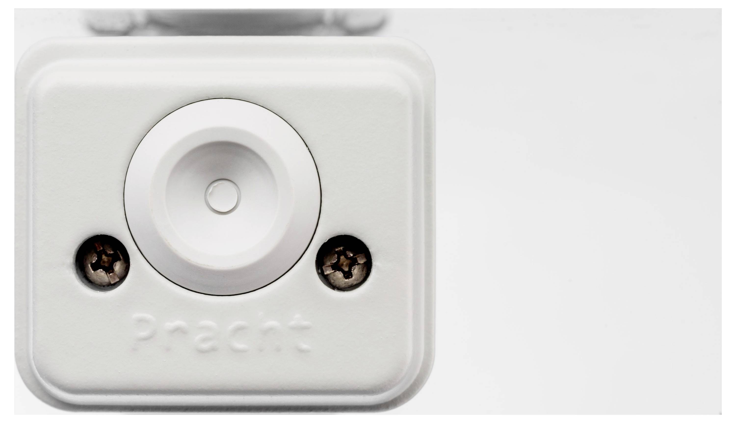 Biała prostokątna skrzynka z przyciskiem pośrodku, pod spodem napis 'Pracht'.