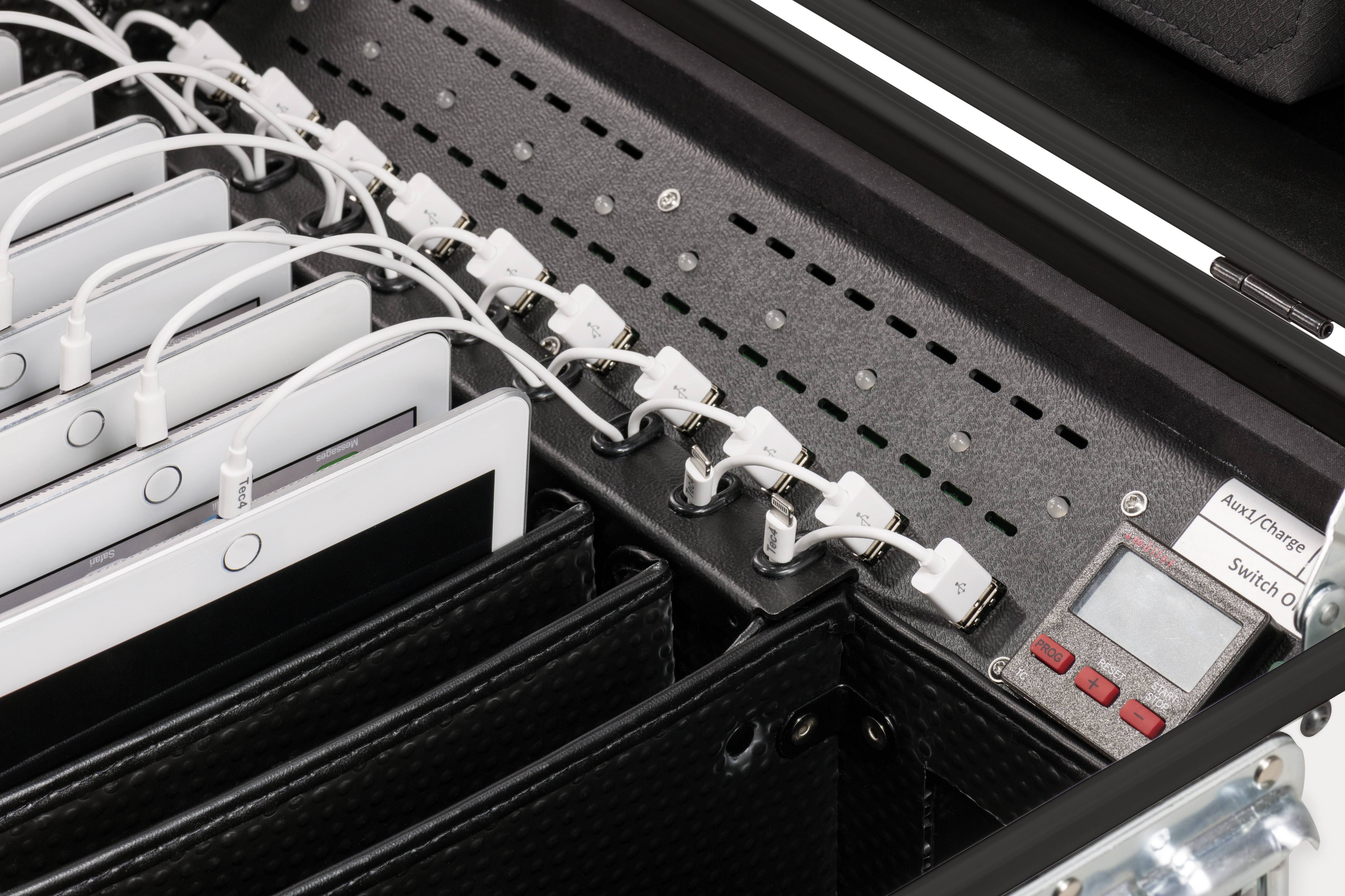 Kilka tabletów jest podłączonych do stacji ładującej. Kable USB są podłączone, aby jednocześnie naładować urządzenia.