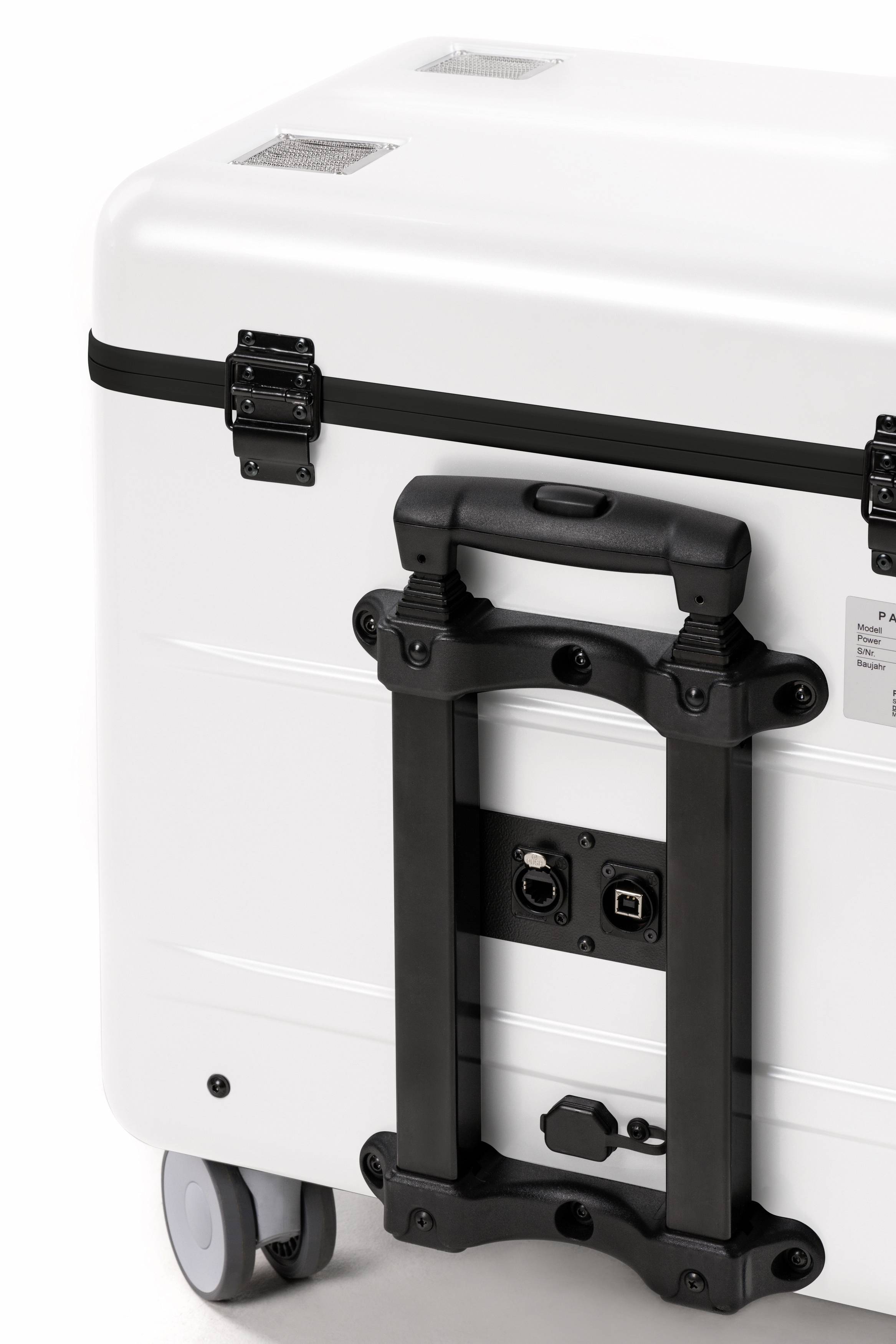 Biały, przewożny kuferek z czarnymi zamkami i uchwytami. Widoczne gniazda przyłączeniowe po bokach. Nadaje się do transportu i ochrony sprzętu.