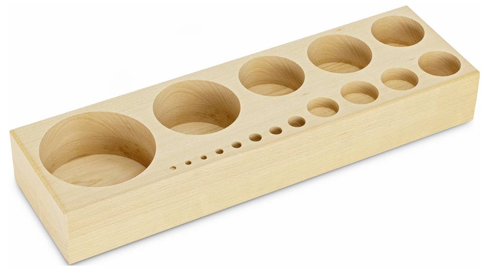 Drewniany blok z otworami o różnych rozmiarach, prawdopodobnie do sortowania lub do edukacji metodą Montessori.