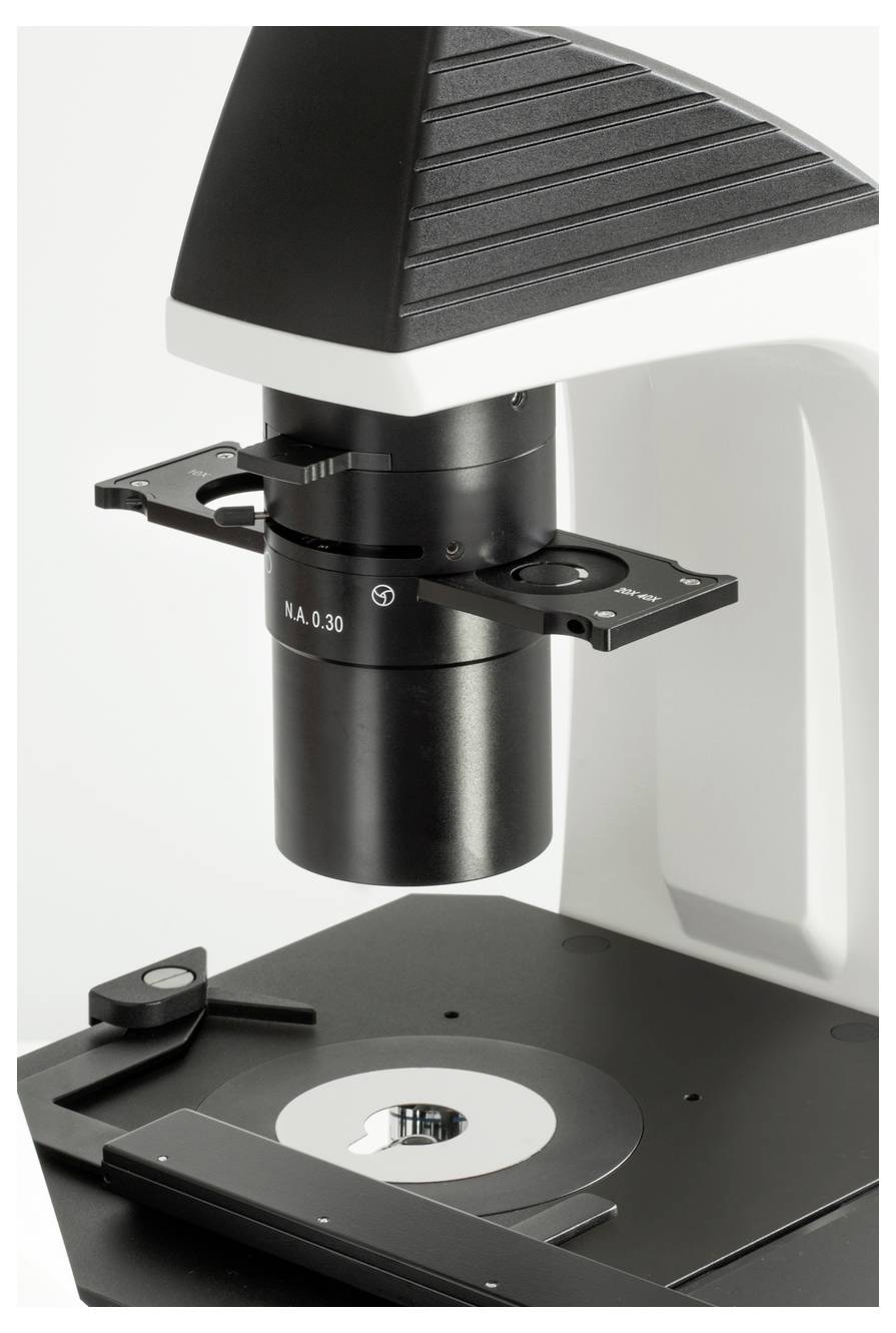 Mikroskop z opcją powiększenia, na którym umieszczono szkiełko podstawowe; używane do szczegółowego badania małych struktur w laboratorium.