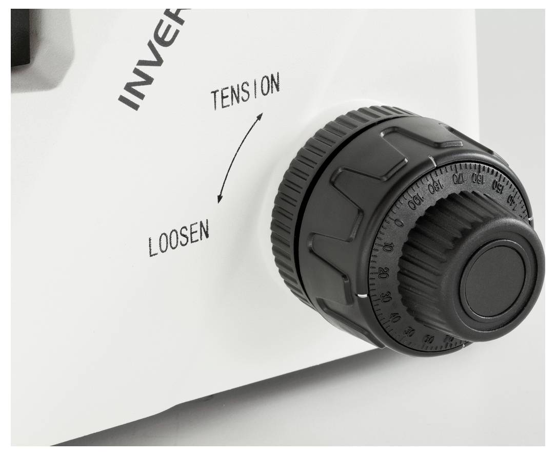 Zbliżenie pokrętła na urządzeniu. Pokrętło jest oznaczone napisami 'Tension' i 'Loosen', z zaznaczoną strzałką wskazującą kierunek obrotu.