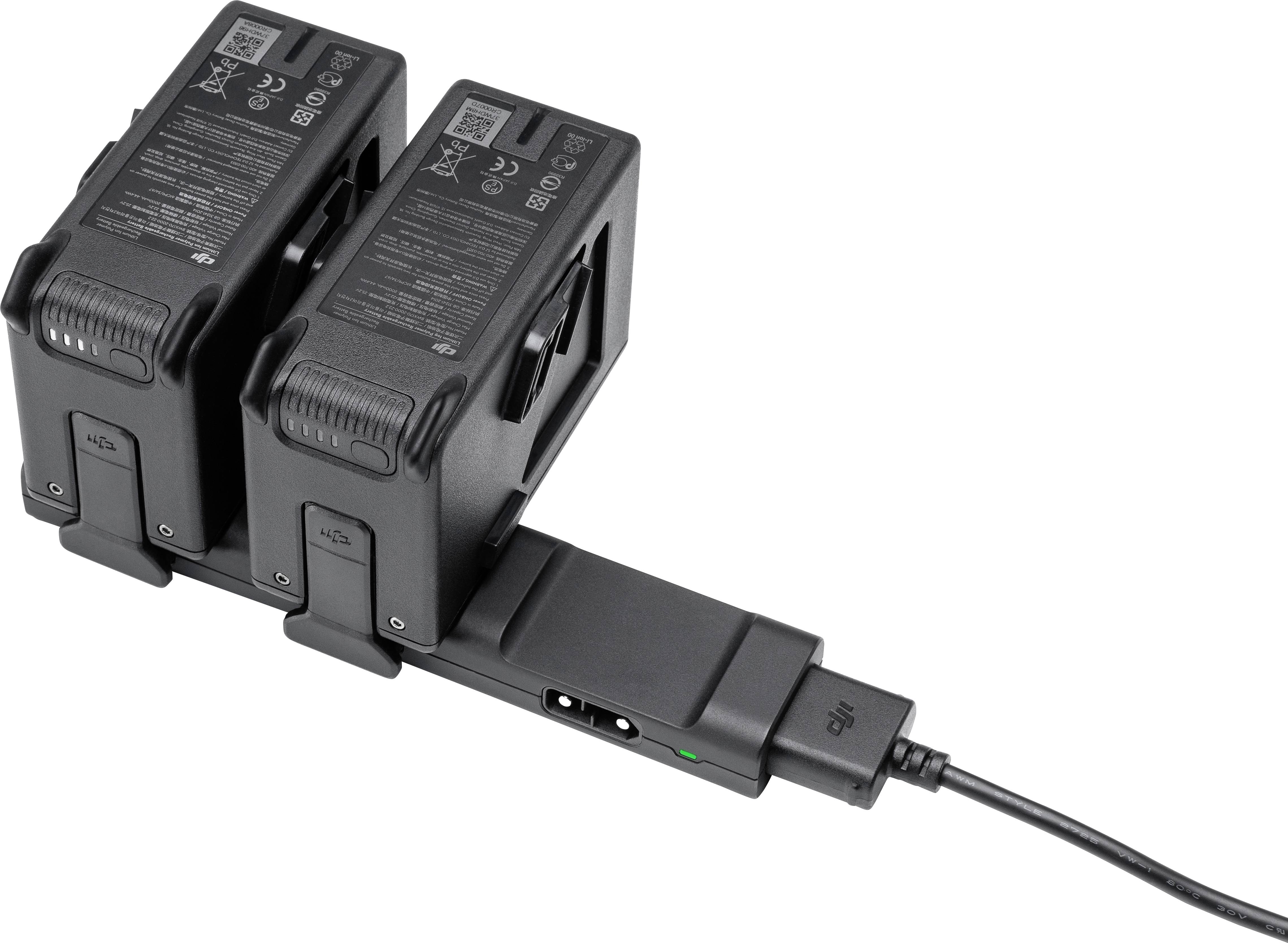 Dwie czarne baterie są jednocześnie ładowane na ładowarce zasilanej przewodem elektrycznym.