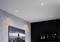 Przestronna izba z szarą panoramą Empire State Building na ścianie, czterema wbudowanymi lampami sufitowymi i czarnymi regałami na książki.