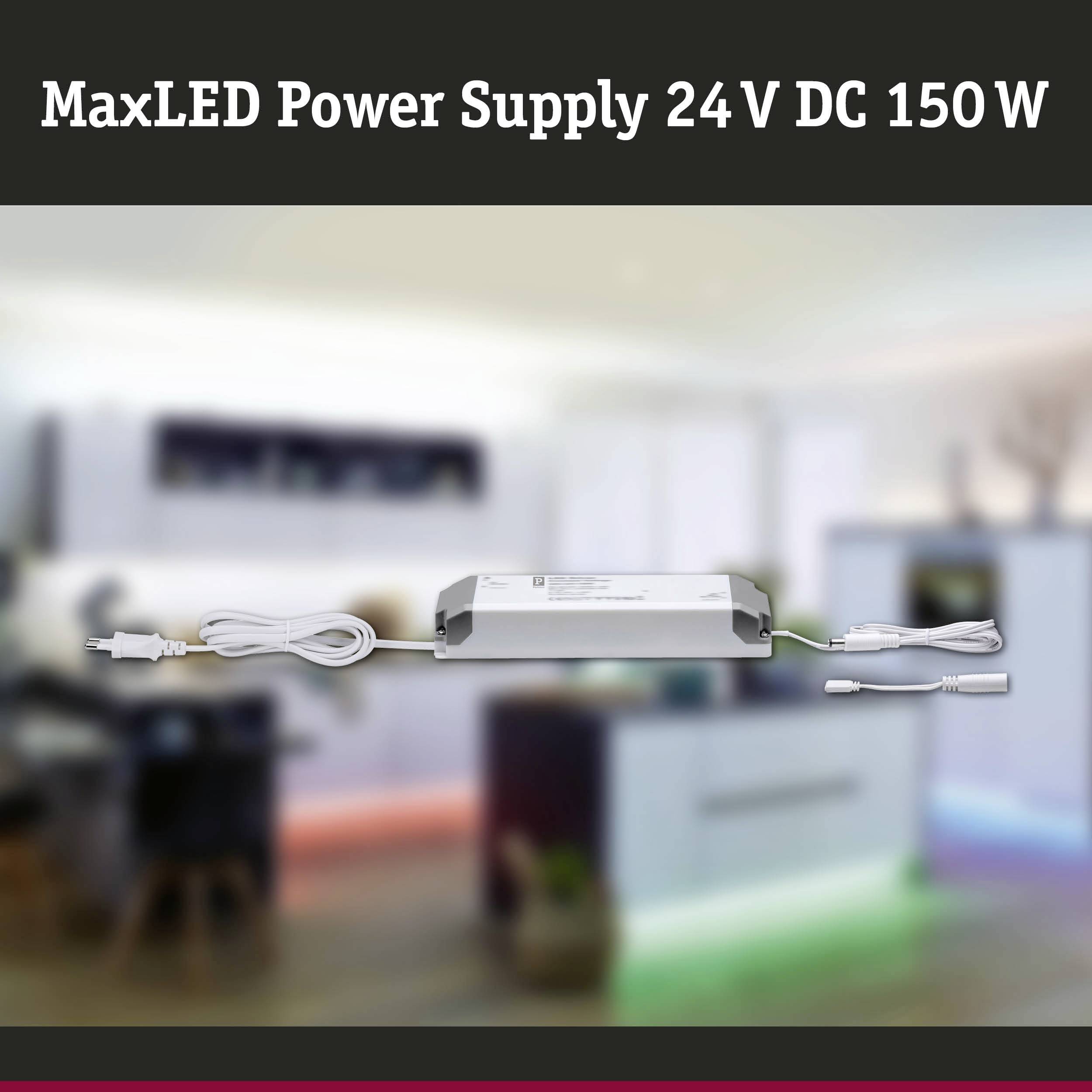 Zasilacz do MaxLED 24V DC 150W, widoczny na pierwszym planie. Tło rozmyte, prawdopodobnie pomieszczenie z oświetleniem.