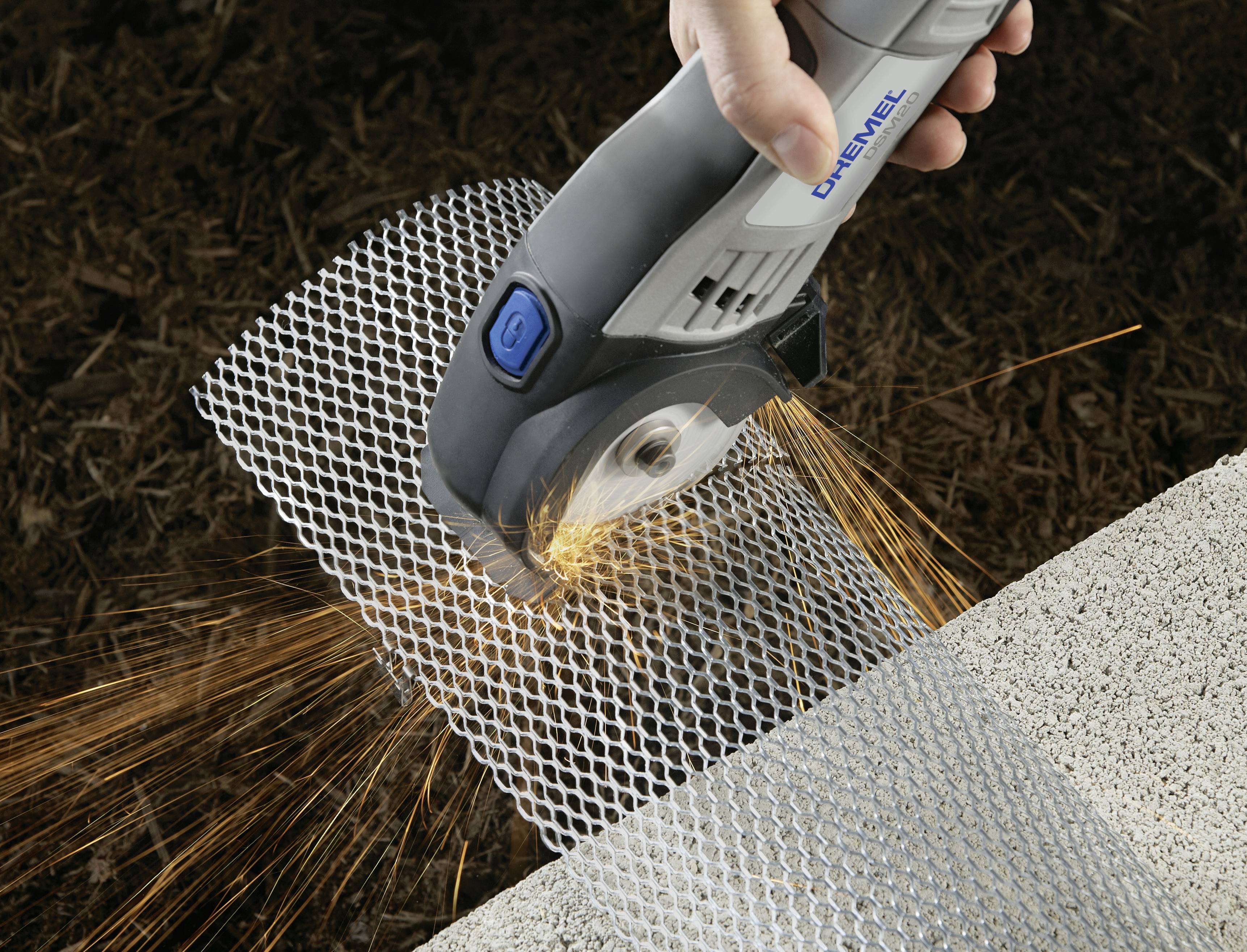 Narzędzie przecina metalową siatkę snopem iskier. Ręka trzyma urządzenie, które wykonuje precyzyjny i mocny cięcie.