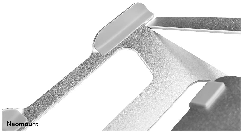 Metalowy stojak na laptopa w zbliżeniu, prezentujący solidną konstrukcję i minimalistyczny design. Nazwa marki 'Neomount' widoczna w lewym dolnym rogu.