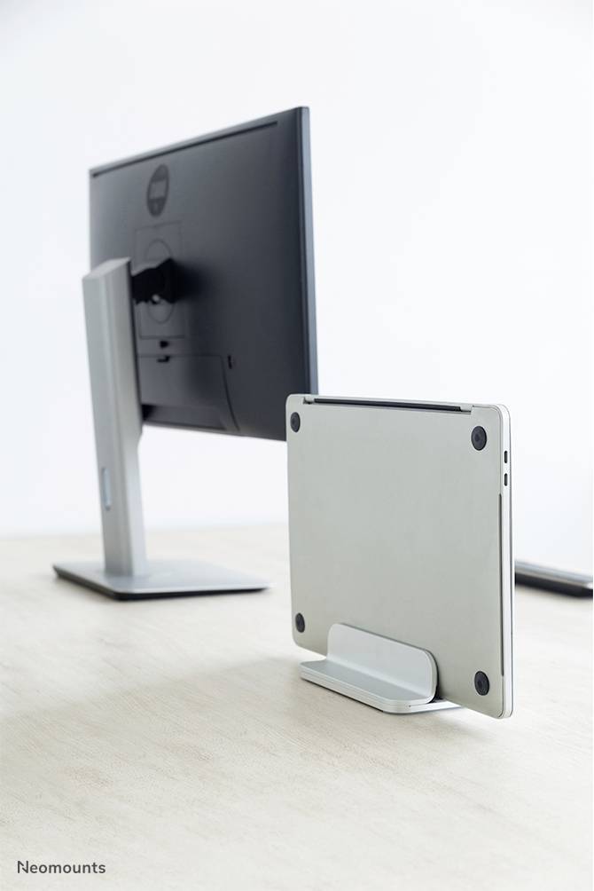 'Dwa monitory na stole: po lewej stronie duży ekran, po prawej cienki ekran w pionowym uchwycie. Oba są szare.'