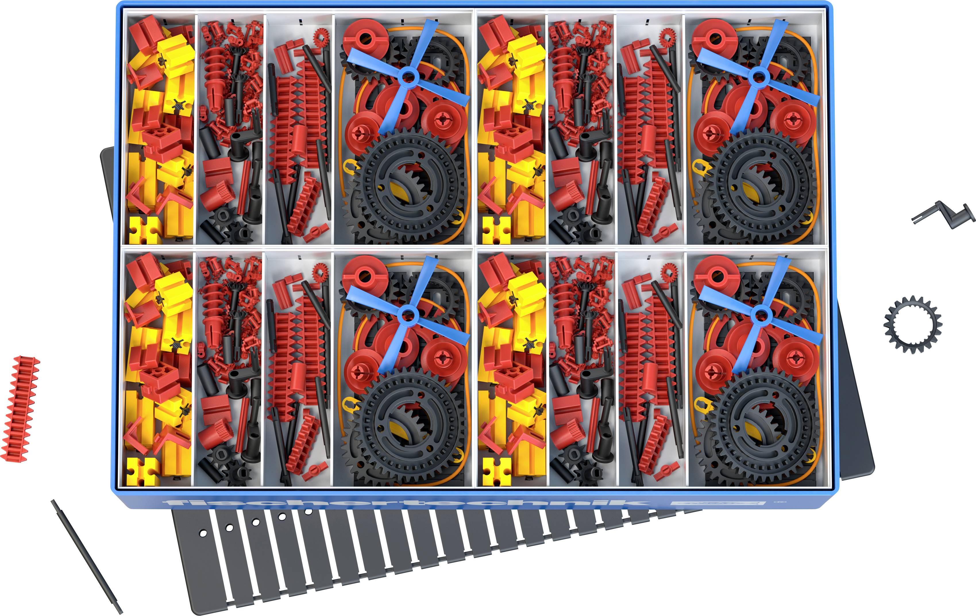 Posortowana skrzynka z klockami i kółkami zębatymi w kolorach czerwonym, żółtym i niebieskim, ułożonymi w ośmiu przegródkach. Różne kształty i rozmiary.