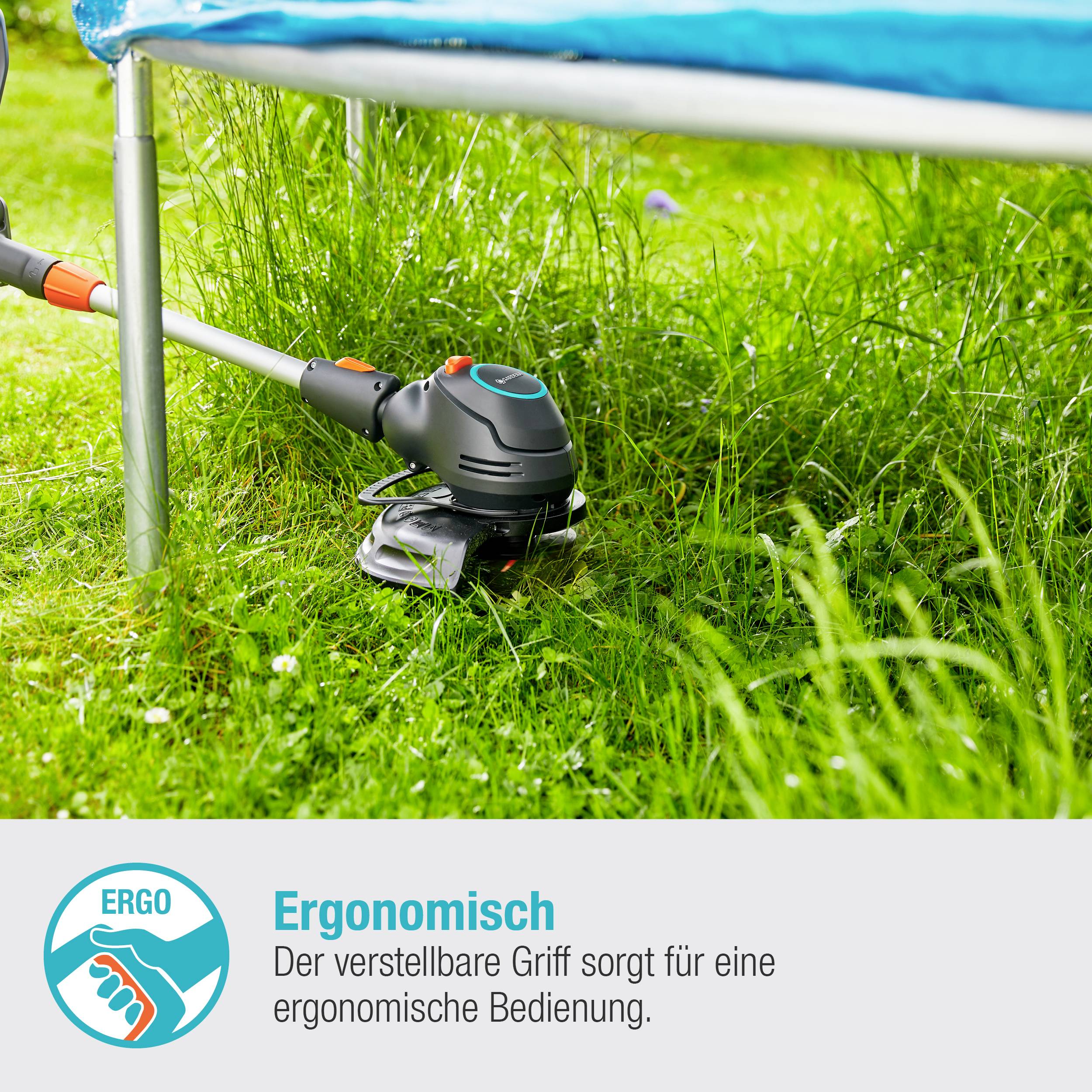 Osoba kosi trawę trymerem pod trampoliną. Trymer posiada regulowaną, ergonomiczną rękojeść.