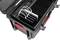 Otwarty kufer z przegrodami, w których ładowane są tablety białymi kablami. Kufer posiada kółka i czerwone uchwyty po bokach.