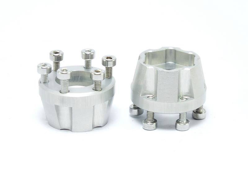 Dwa srebrne elementy metalowe ze śrubami, umieszczone na białej powierzchni. Mają różne kształty i prawdopodobnie służą do montażu.