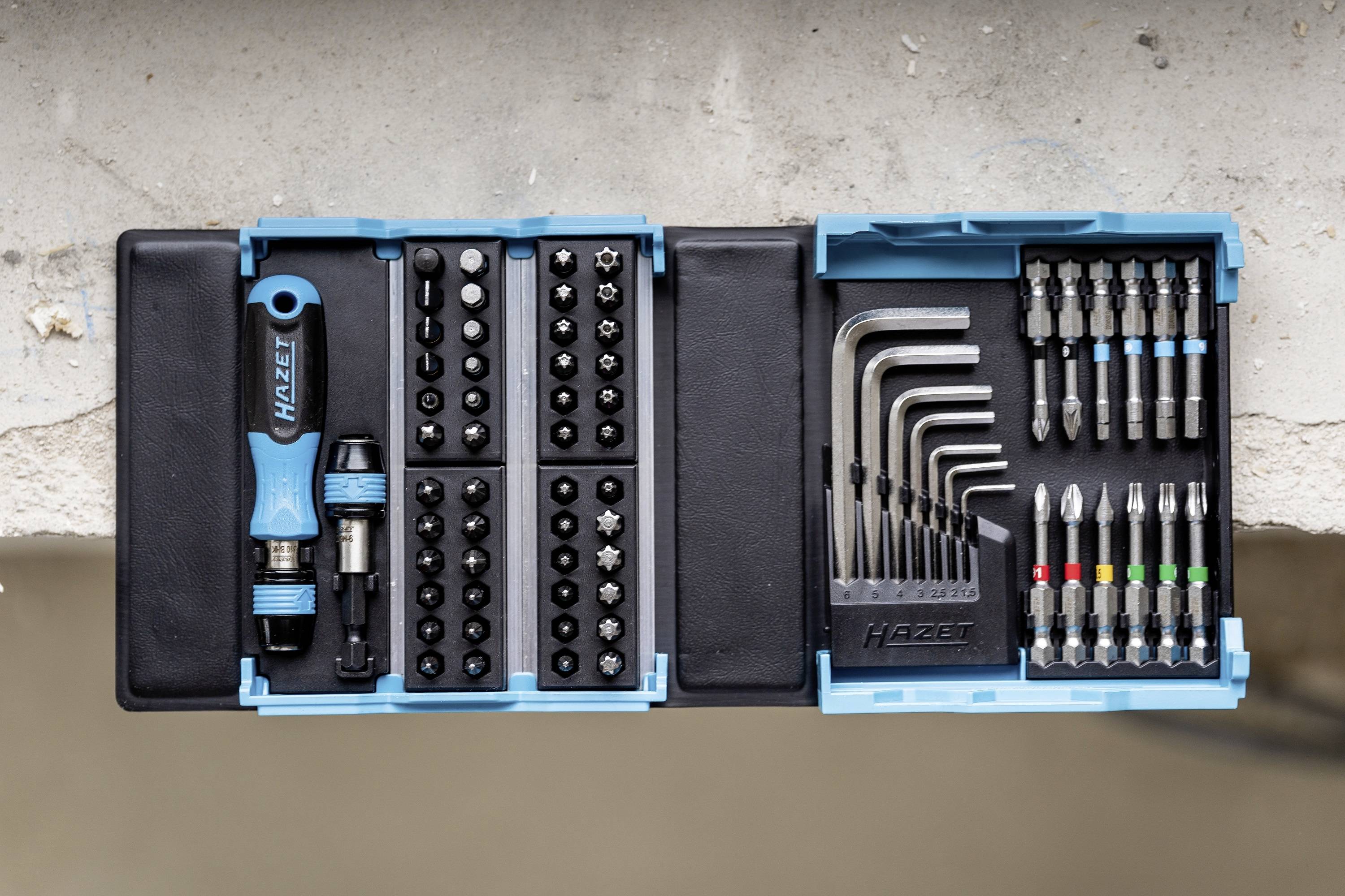 Zestaw narzędzi w niebieskim pudełku z wkrętakiem, grotami i kluczami imbusowymi.