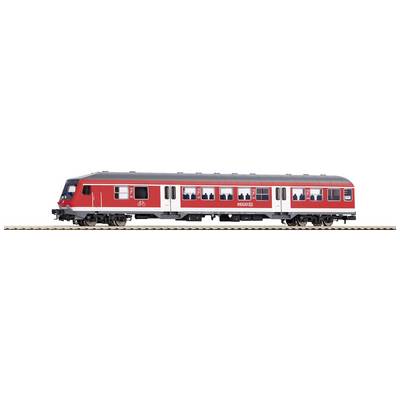 Czerwony wagon kolejowy z białymi detalami jedzie po torach. Widać nieliczne okna i drzwi. Pociąg należy do kolei.
