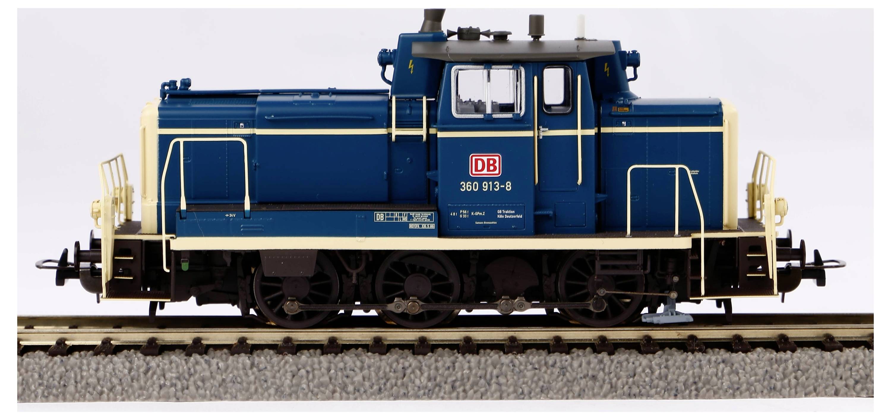Niebiesko-żółta lokomotywa 360 913-8 Deutsche Bahn na torach, widok z boku.