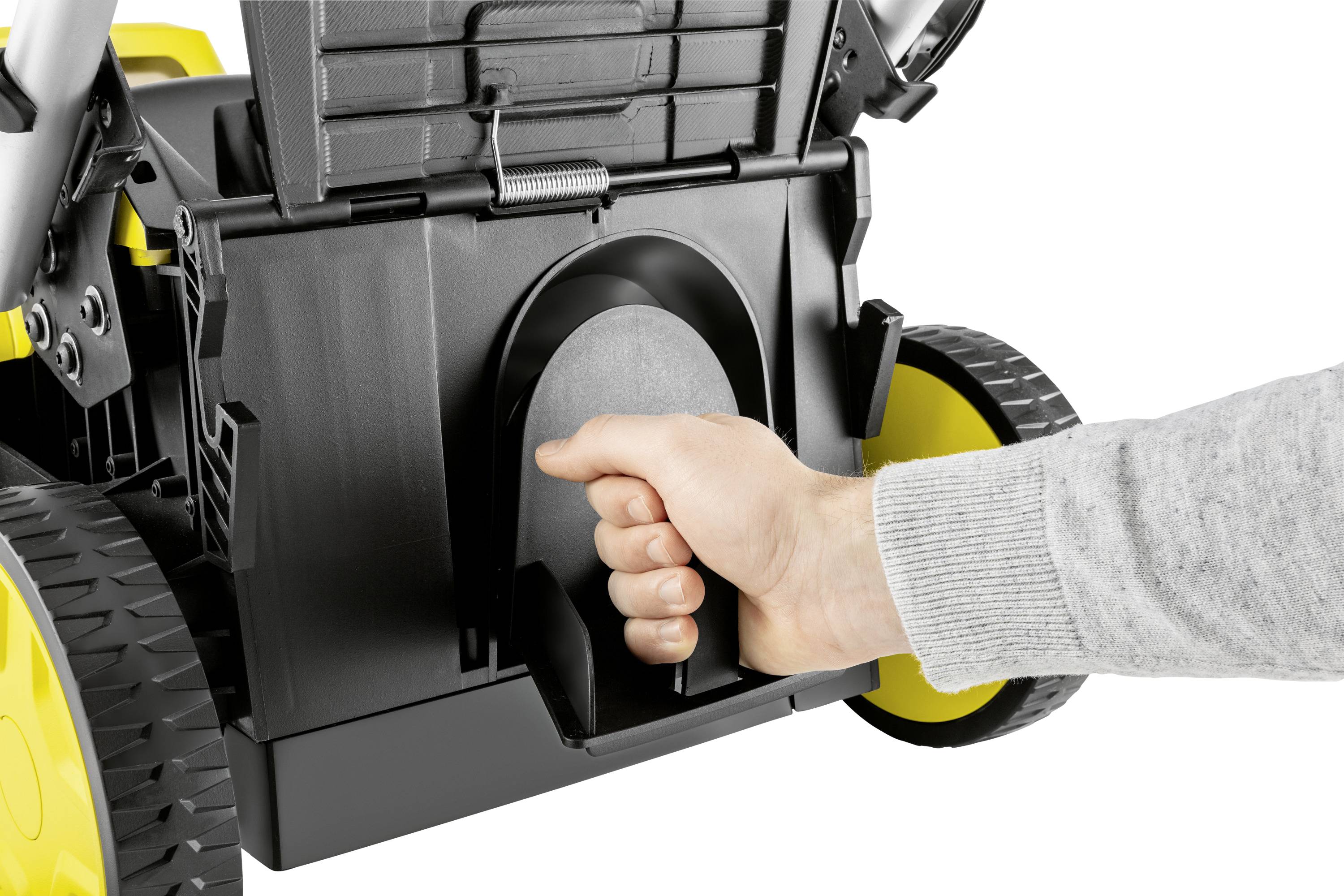 Ręka pociąga za dźwignię na żółnej obudowie urządzenia, prawdopodobnie w celu obsługi lub konserwacji. Zbliżenie mechanizmu.