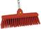 Czerwona miotła z twardymi, podłużnymi włoskami i metalowym uchwytem, odpowiednia do zamiatania grubego brudu na twardych powierzchniach.