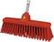 Czerwona miotła z twardymi, gęstymi włóknami i srebrnym uchwytem, przeznaczona do zamiatania podłóg.