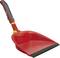 Czerwona zmiotka z czarną rączką i gumową krawędzią, odpowiednia do zbierania brudu i śmieci.