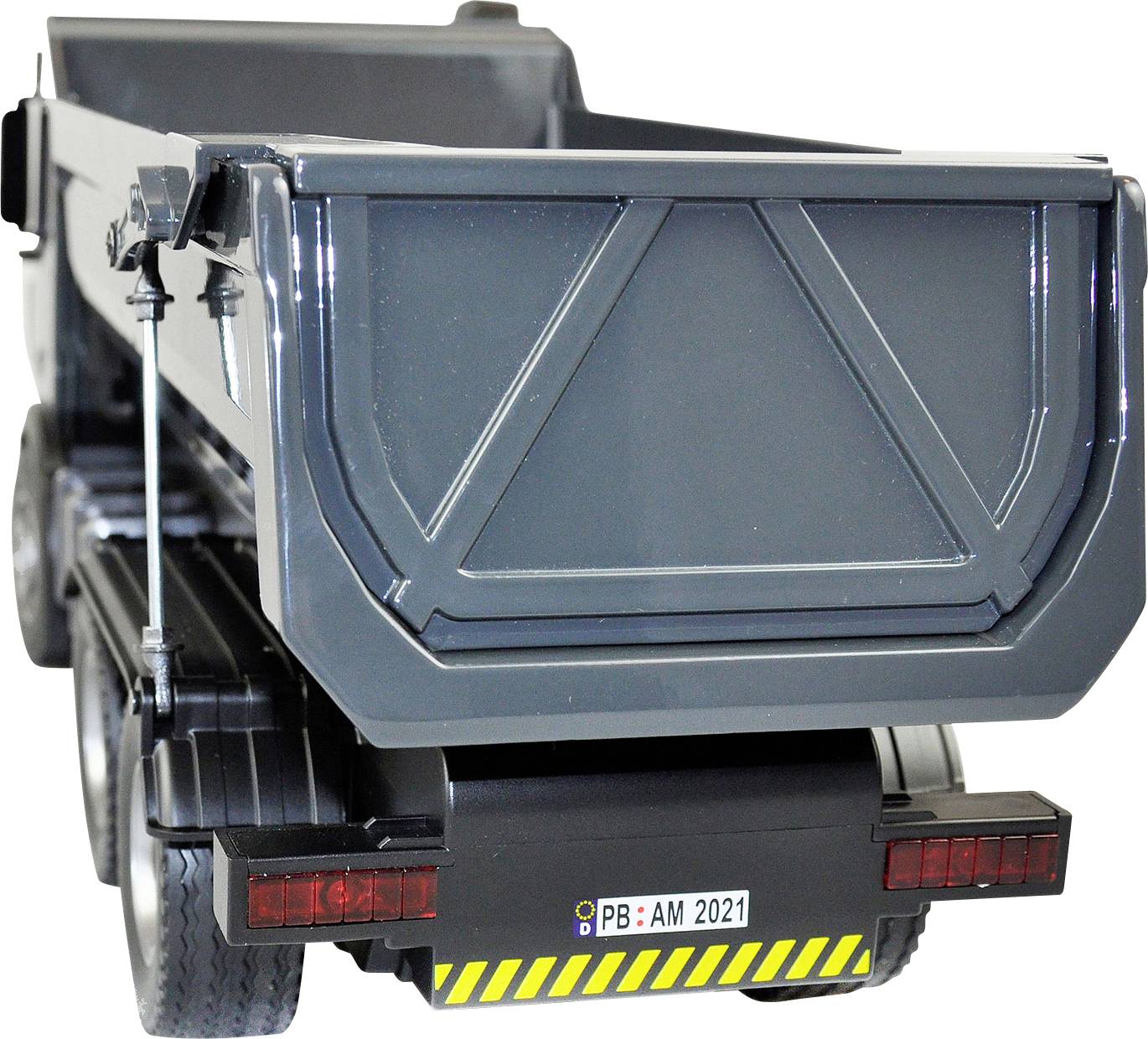 Szary samochód ciężarowy z otwartą przestrzenią ładunkową i żółtą tablicą rejestracyjną 'PB: AM 2021', stoi na białym tle.