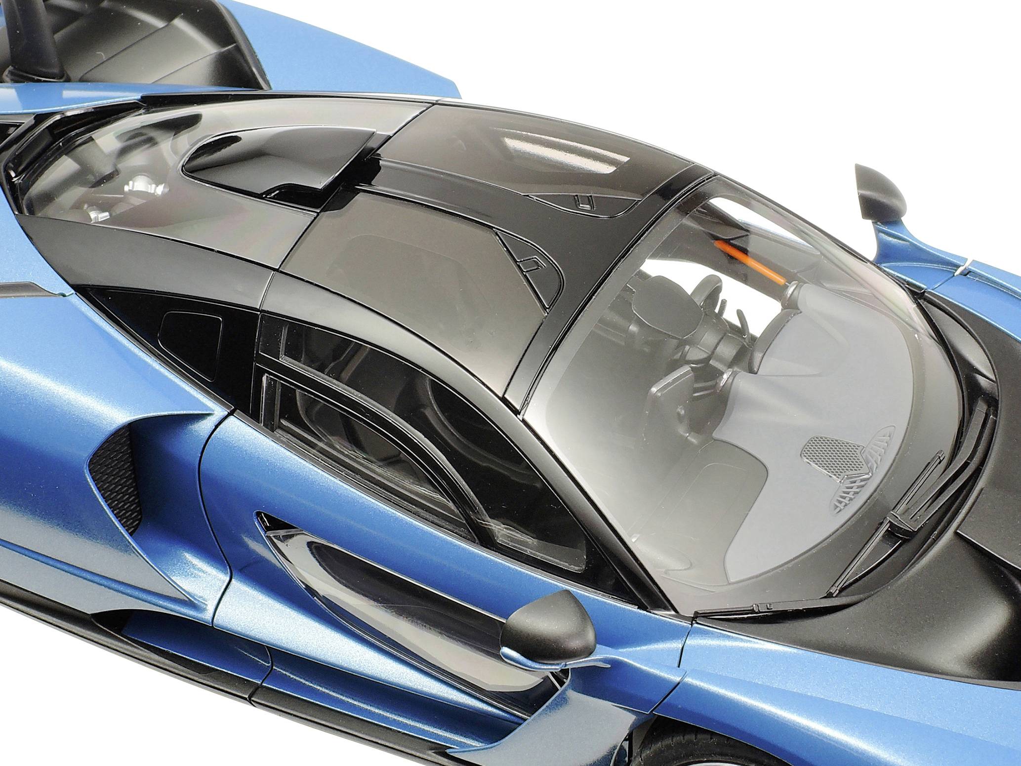 Niebieski model samochodu sportowego o futurystycznym designie z czarnym dachem, przedstawiony z perspektywy widoku z góry.