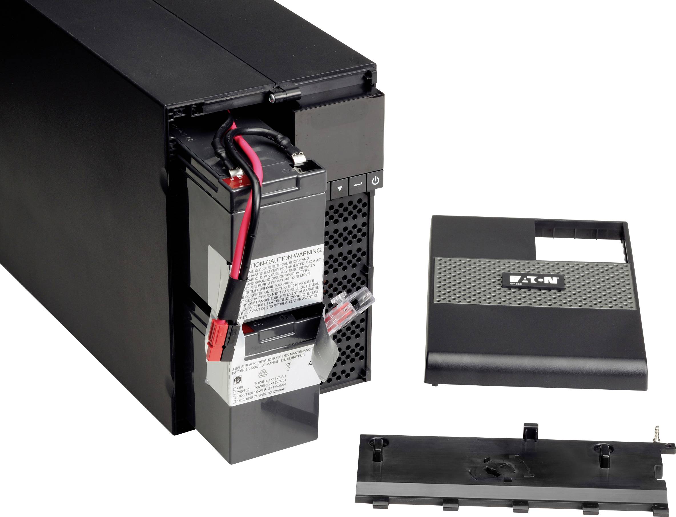 Urządzenie UPS z otwartą pokrywą komory baterii, ukazujące wyjmowalną baterię z czerwonymi i czarnymi przewodami.