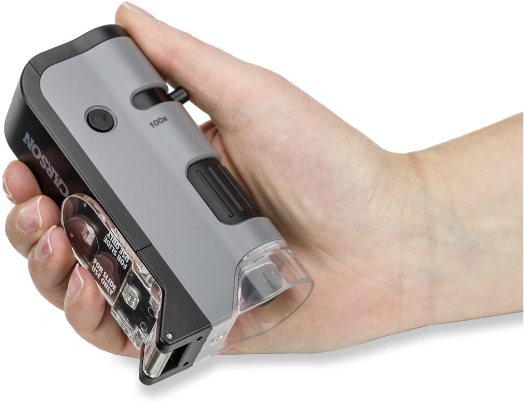 Ręka trzyma przenośny mikroskop z szarą obudową o 100-krotnym powiększeniu, odpowiedni do szybkiego oglądania małych obiektów.
