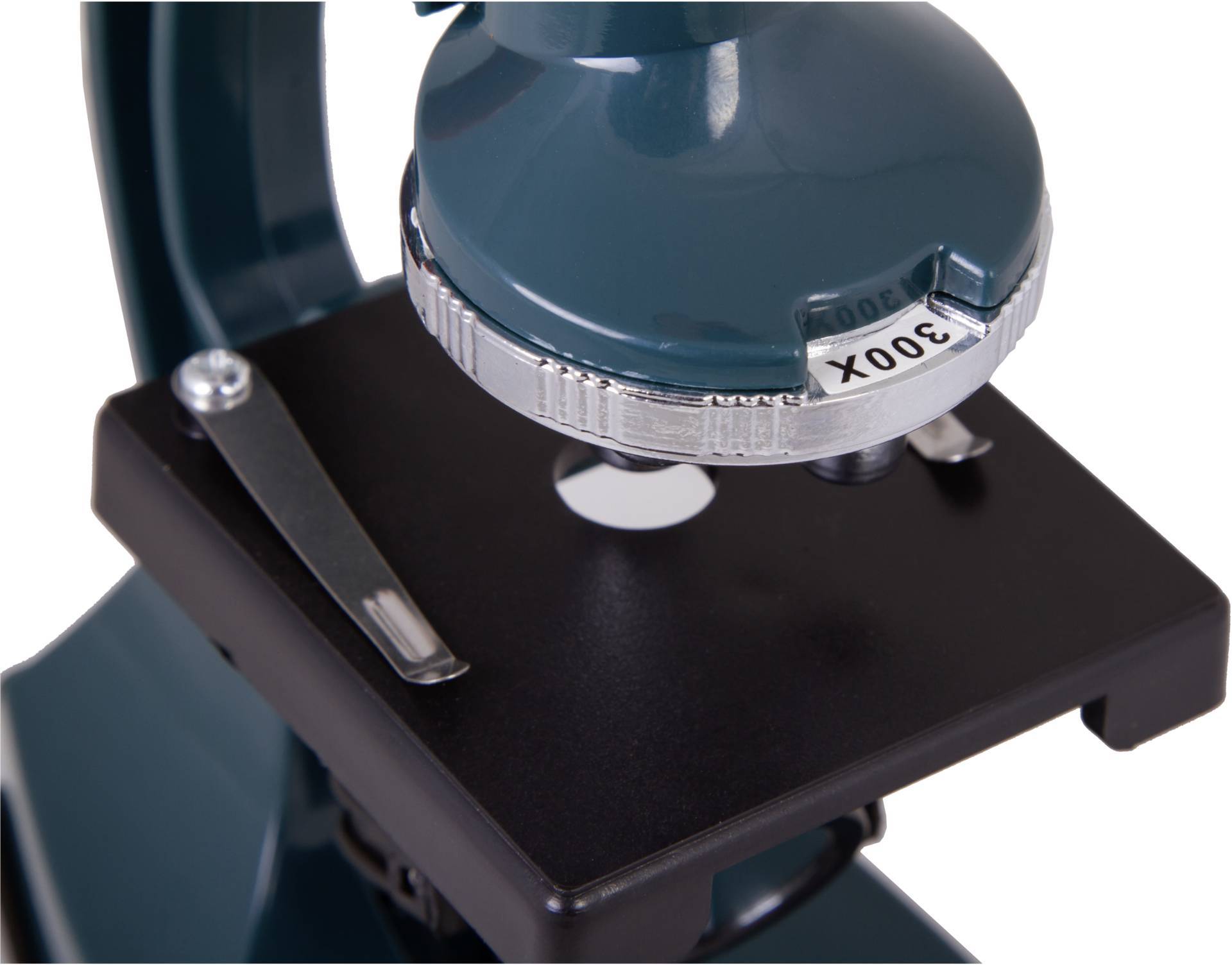 Zielony mikroskop z ustawieniem powiększenia '300X' na czarnym szkiełku podstawowym.