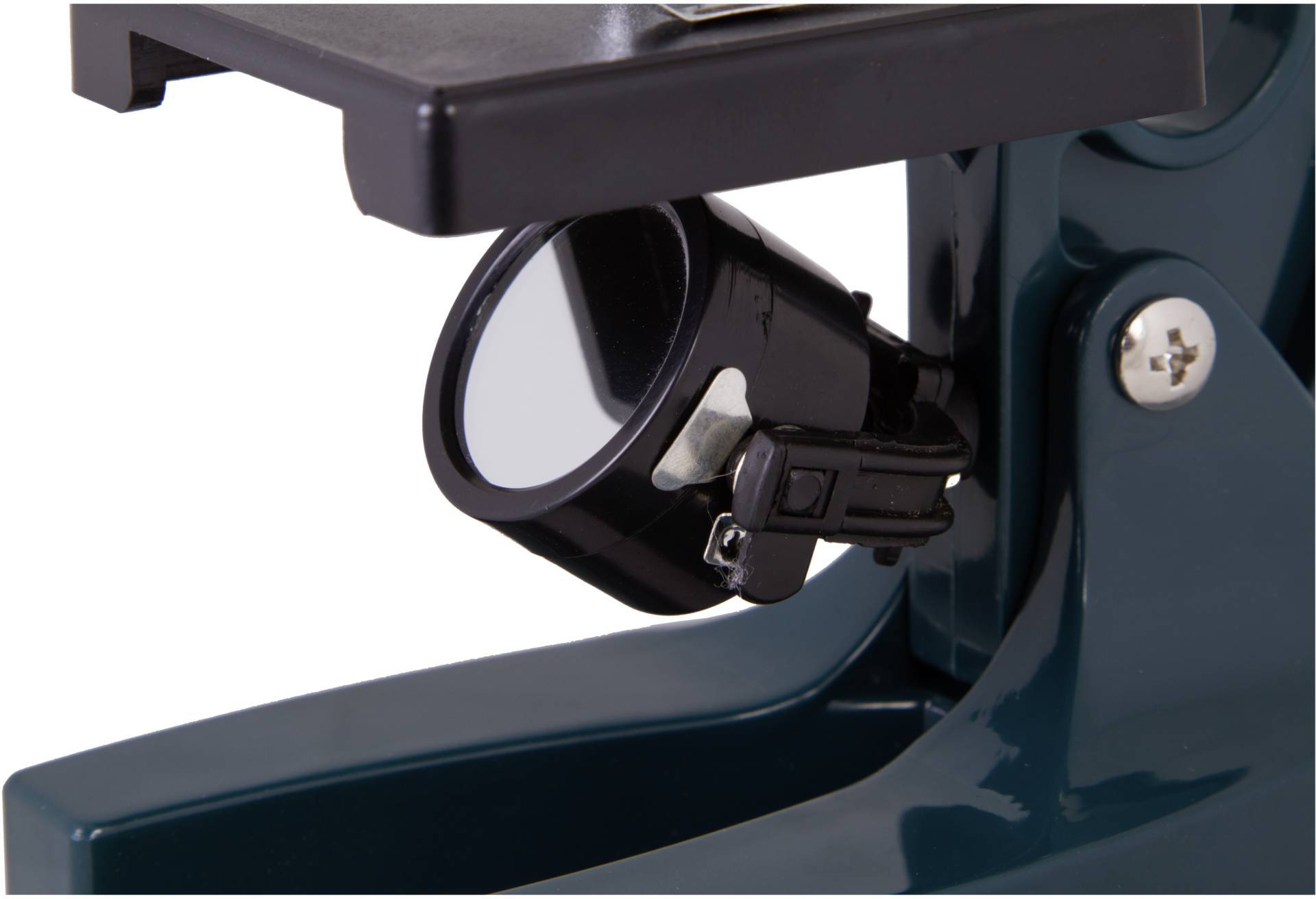 Zielony mikroskop z czarnym uchwytem zwierciadła, pewnie zamocowanym u podstawy. Zwierciadło jest pochylone i gotowe do odbijania światła.