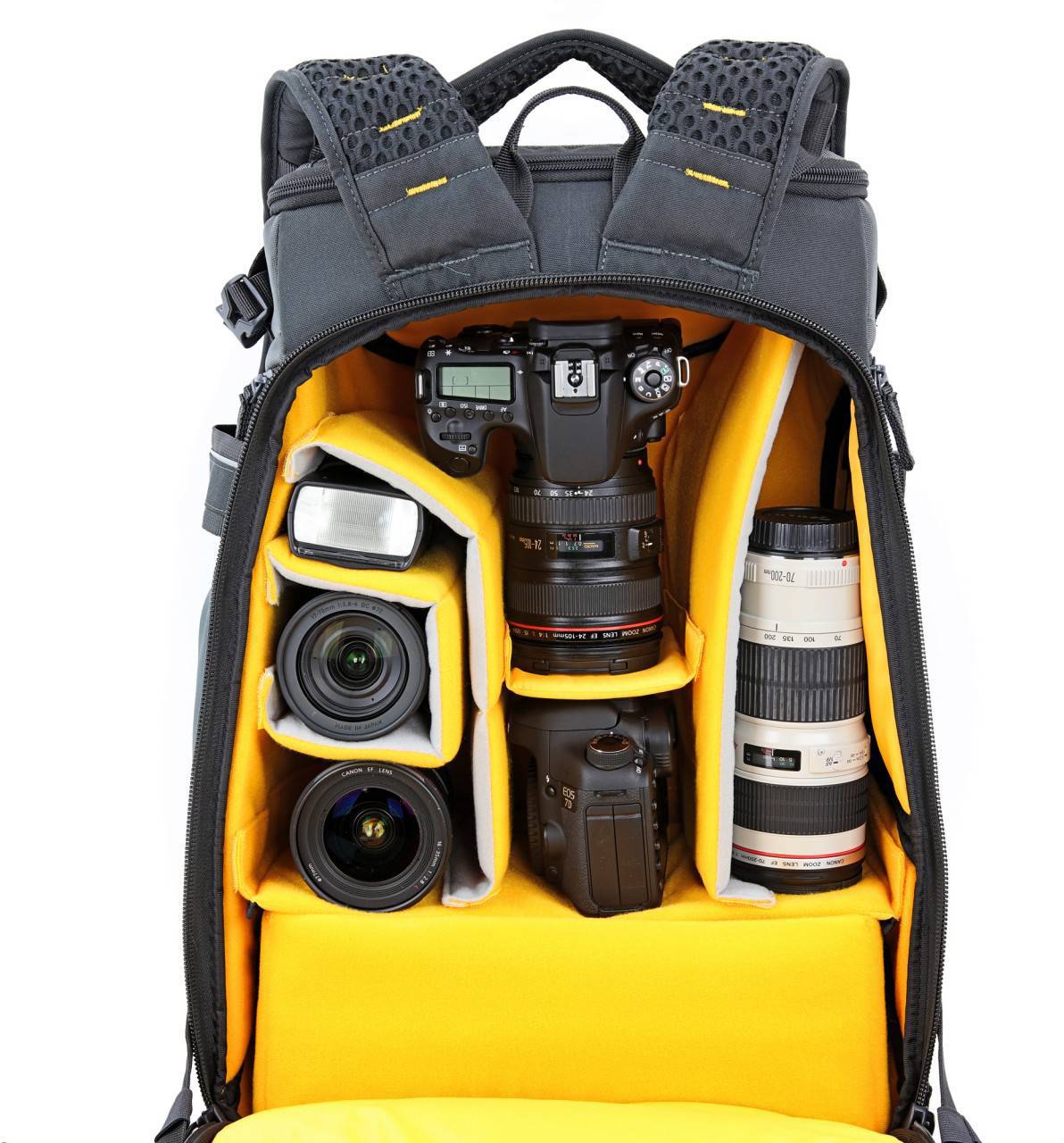Plecak fotograficzny jest otwarty i prezentuje kilka obiektywów oraz korpusów aparatów, starannie ułożonych w żółtych przegródkach.