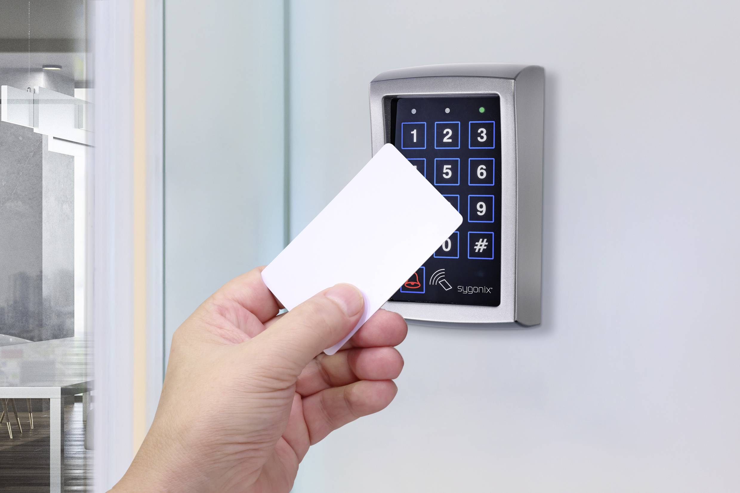 Dłoń trzyma kartę dostępową przed elektronicznym zamkiem szyfrowym na drzwiach, gotowa do użycia kontroli dostępu.