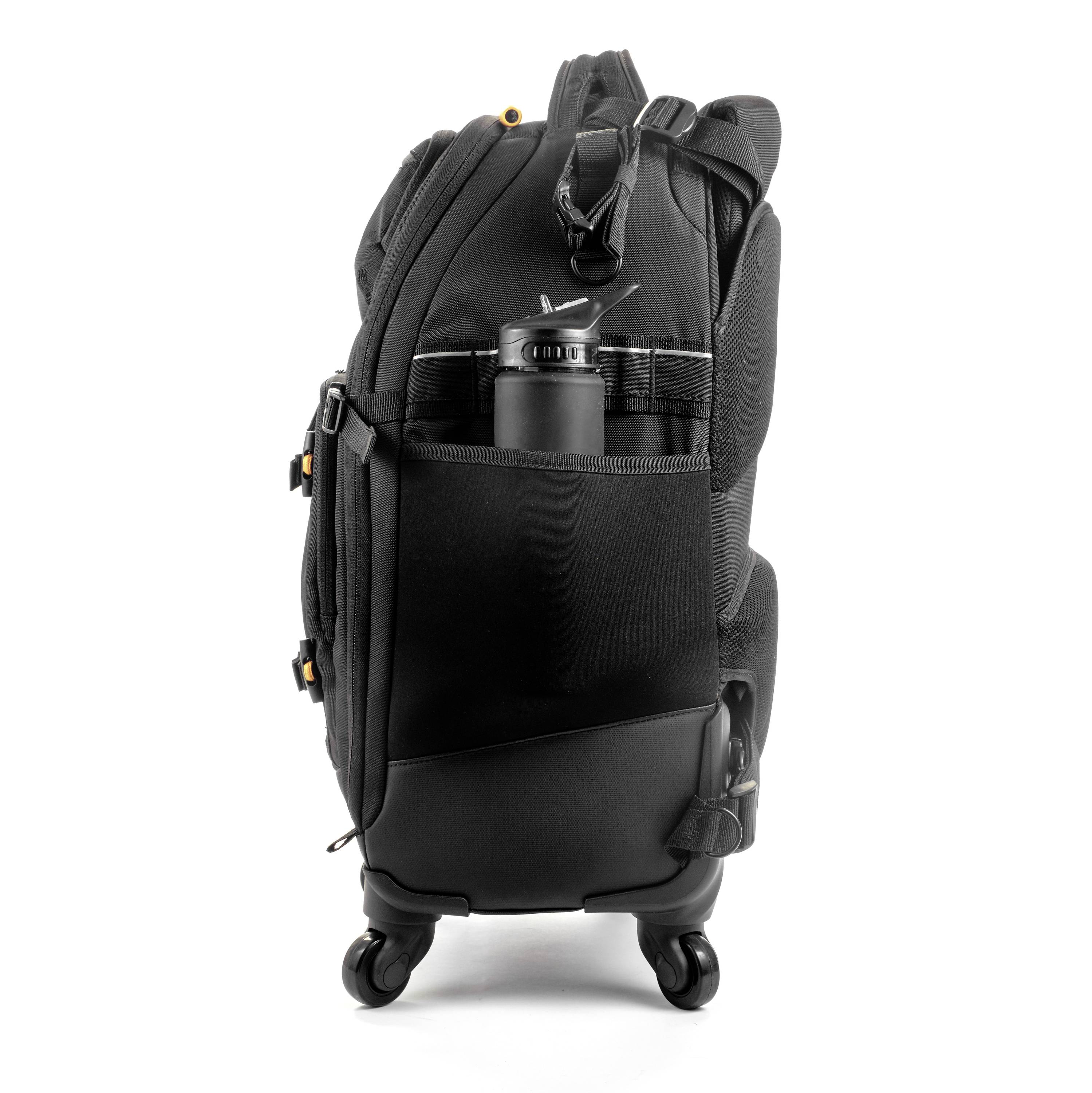 Czarny plecak z wieloma komorami, siateczkową kieszenią z boku oraz miejscem na butelkę wody; stojący pionowo na czterech kółkach.