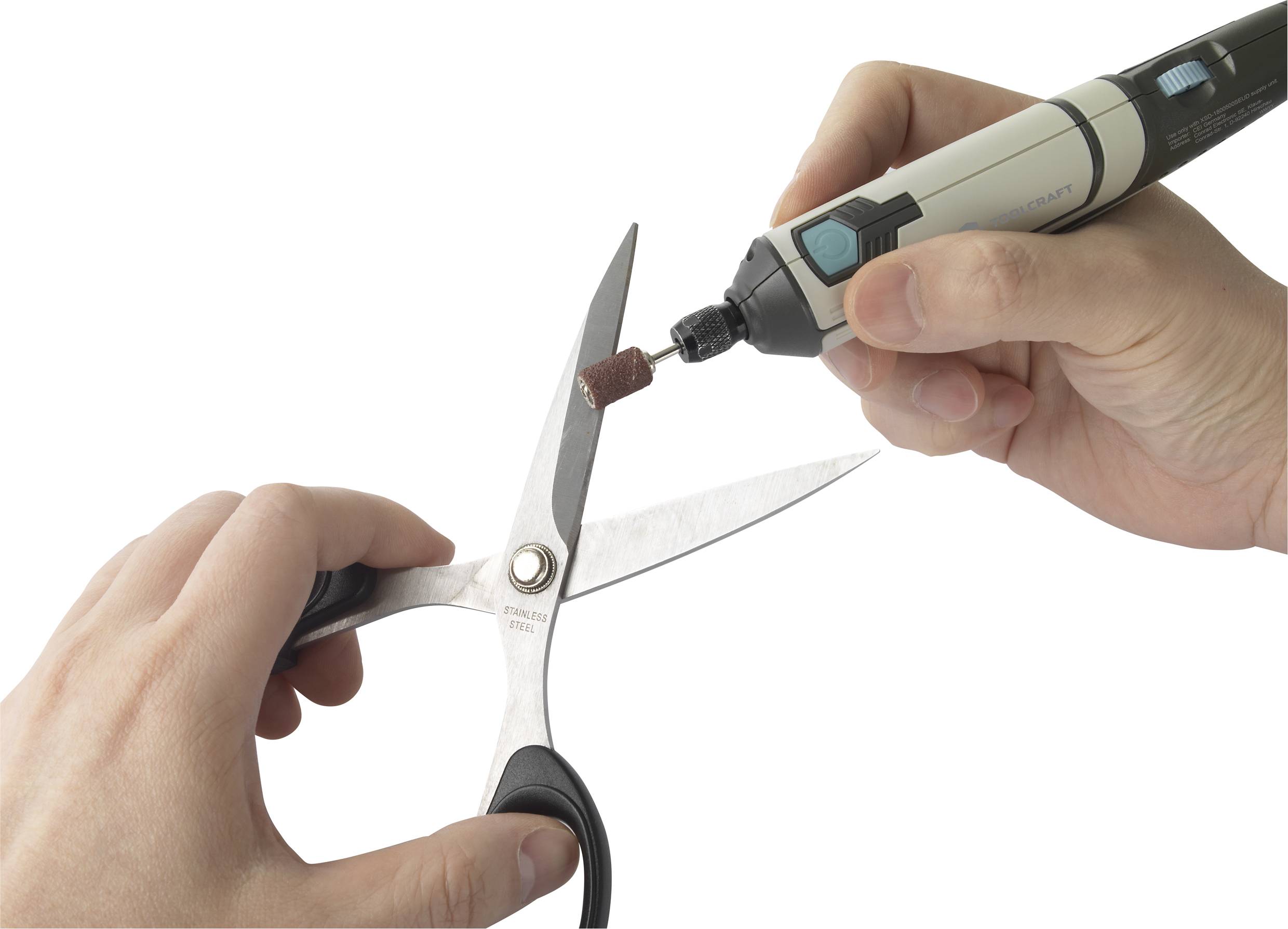 'Jedna ręka trzyma nożyce, podczas gdy druga prowadzi nasadkę tnącą do wielofunkcyjnego narzędzia w kierunku nożyc.'